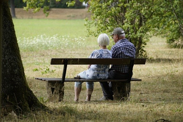 starý pár sedící na lavičce